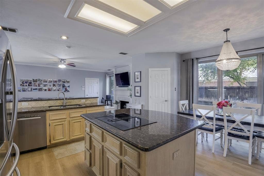 1200 Lakeway Drive, Plano, TX 75075 Kitchen island with a cooktop, stone countertops, stainless steel appliances, and a coffered ceiling