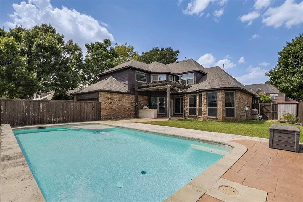 1200 Lakeway Drive, Plano, TX 75075 Expansive backyard with a rectangular swimming pool, concrete pool decking, and stamped concrete patio