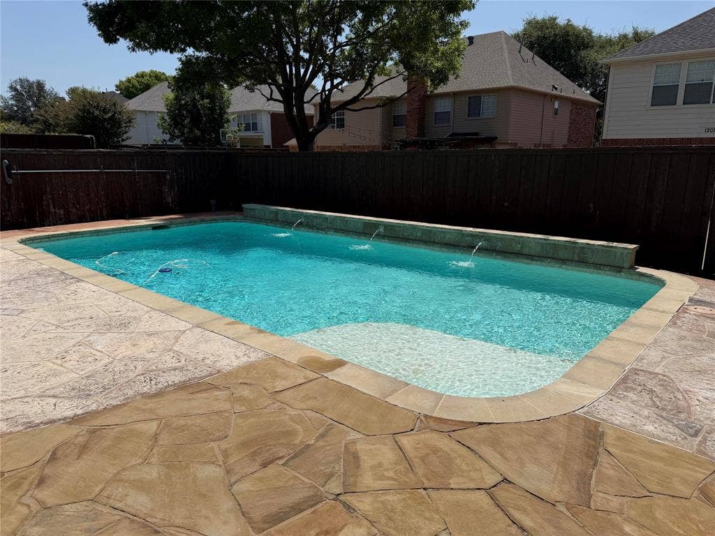 1200 Lakeway Drive, Plano, TX 75075 In-ground swimming pool with water features, integrated steps, and flagstone coping