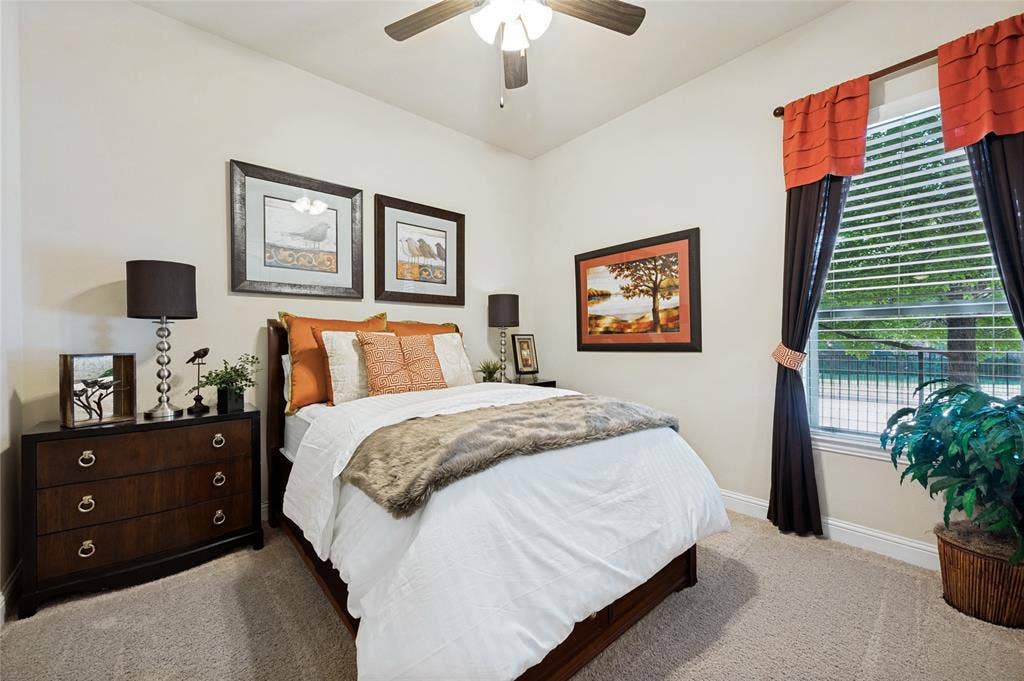 The downstairs guest suite features a ceiling fan, a walk-in closet, and an adjacent bathroom equipped with a standalone shower.