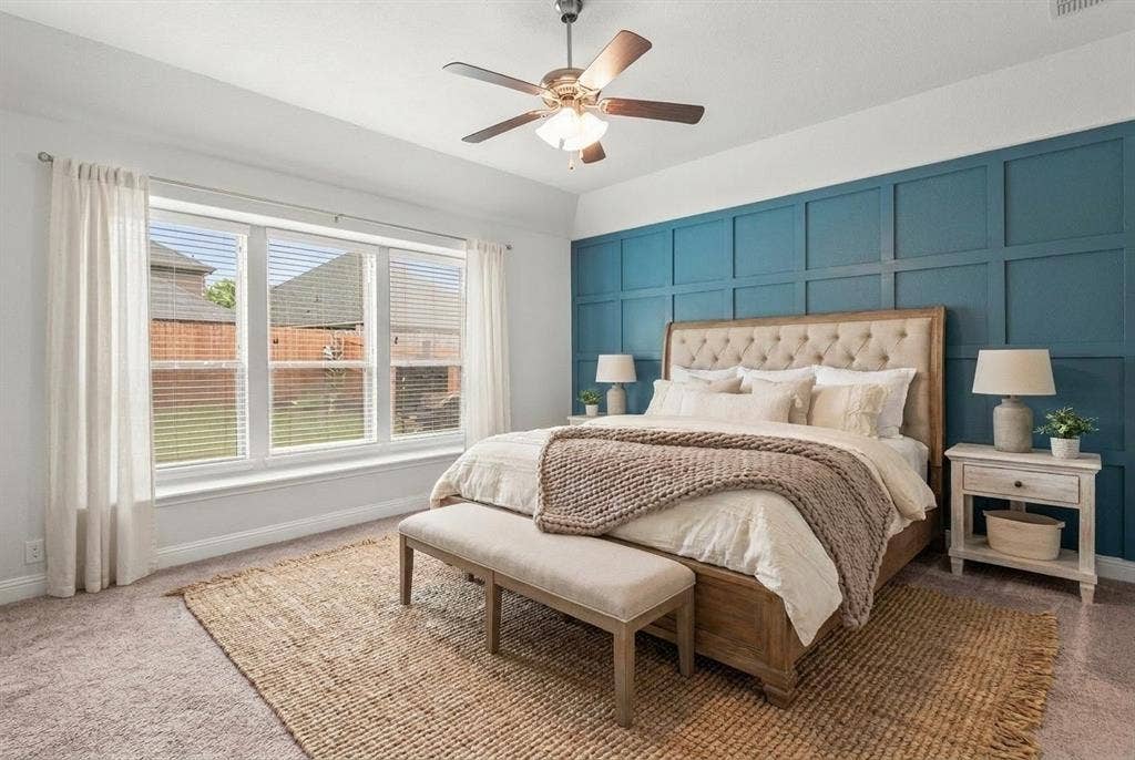Spacious Primary Bedroom with window seat and ceiling fan.