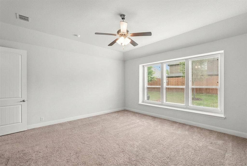 Primary bedroom privately tucked toward the rear of the home, split from other two bedrooms. Views overlooking the peaceful backyard.