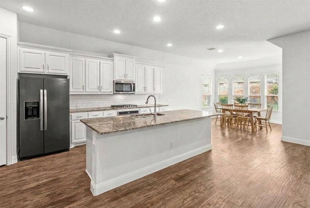 Stainless appliances and spacious island, great for entertaining. Views leading to the dining room with bay windows overlooking the peaceful backyard.
