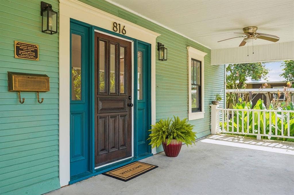 816 W Congress Street, Denton, TX 76201 Covered front porch featuring a ceiling fan, white railing, and a wood-panel exterior door with sidelights