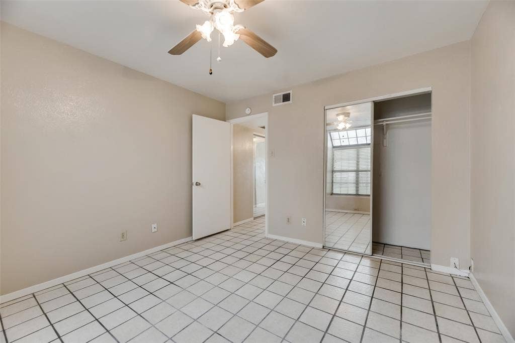Unfurnished bedroom featuring a closet, ceiling fan, and light tile flooring