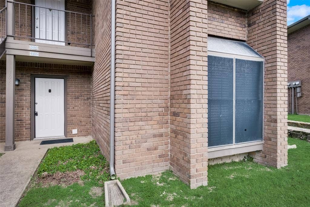 Doorway to property featuring a balcony and a lawn