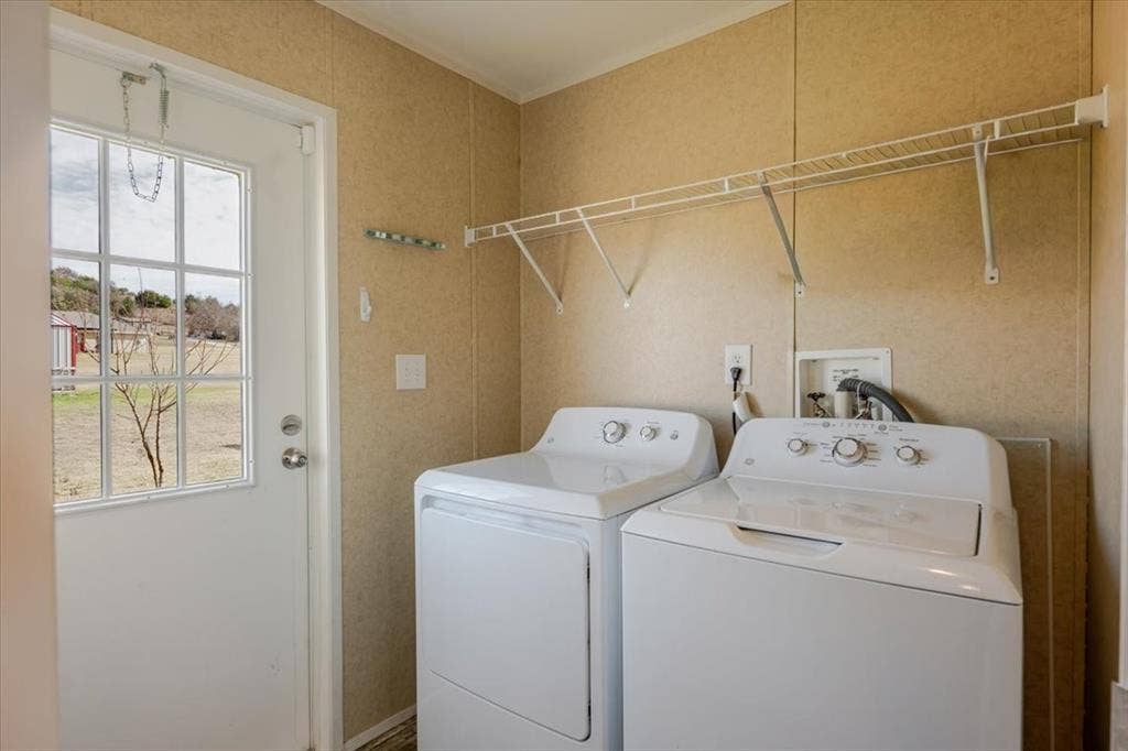 126 Starry Sky Court, Springtown, TX 76082 Utility room featuring wall-mounted wire shelving, wall-finish flooring, and a white paneled door with windowpanes. Washer and dryer do not convey.