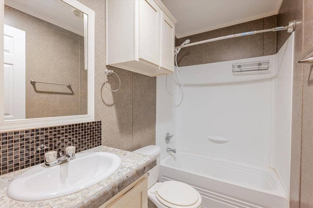 126 Starry Sky Court, Springtown, TX 76082 Spa-inspired bathroom featuring a curved soaking tub with tile surround, dual showerhead with glass enclosure, granite-topped vanity with oval sink, white cabinetry, decorative tile accent band, and recessed lighting