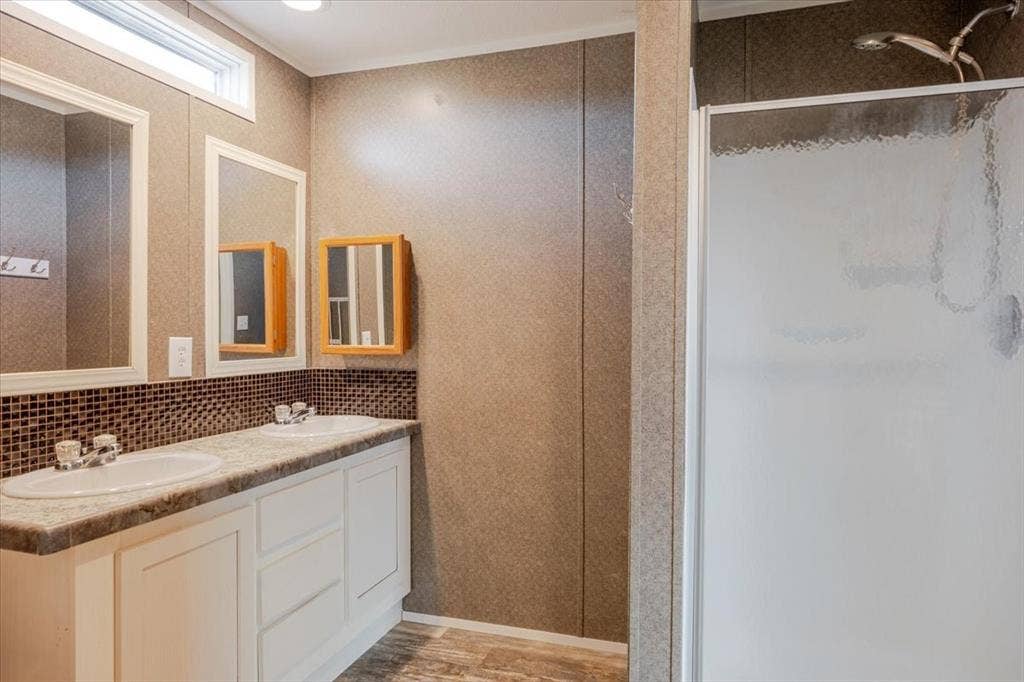 126 Starry Sky Court, Springtown, TX 76082 Dual vanity with white cabinetry, integrated sinks, and individual framed mirrors, separate shower.
