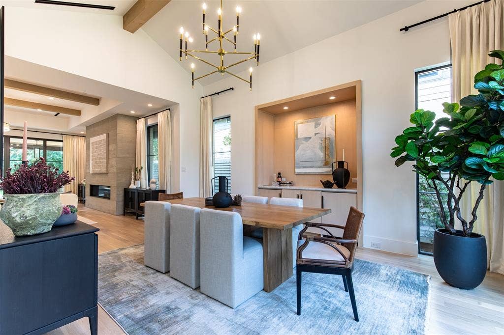 6979 Bob O Link Drive, Dallas, TX 75214 Vaulted ceiling dining area featuring a linear chandelier, wood-finish flooring, and a built-in recessed cabinet with lower storage