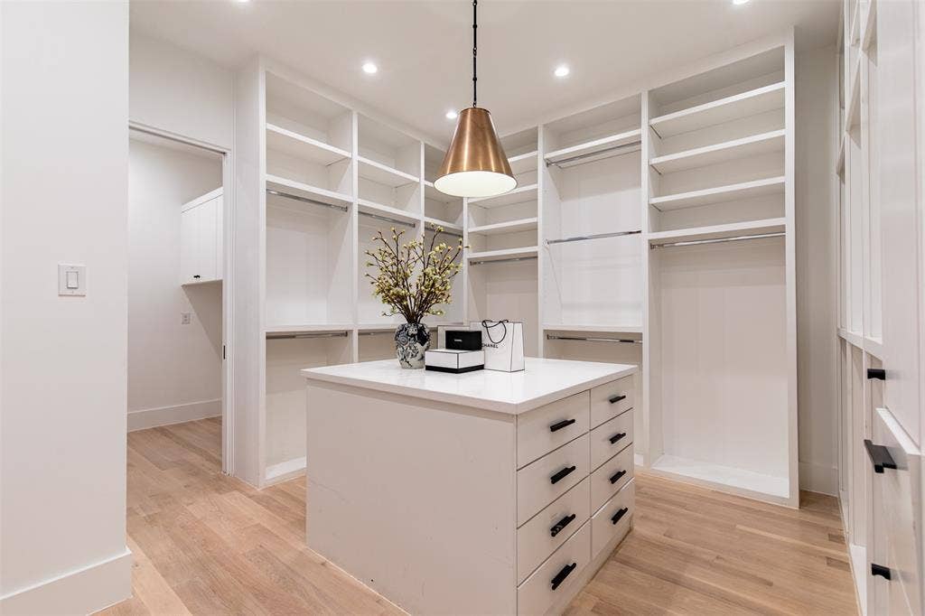6979 Bob O Link Drive, Dallas, TX 75214 Spacious walk-in closet featuring light wood-finish flooring, recessed lighting, and a central island with integrated drawers