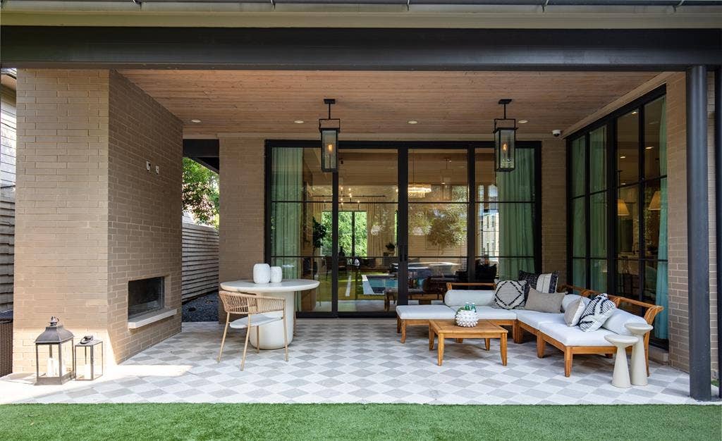 6979 Bob O Link Drive, Dallas, TX 75214 Expansive covered patio featuring a brick fireplace, geometric patterned tile flooring, and a wood-finish ceiling