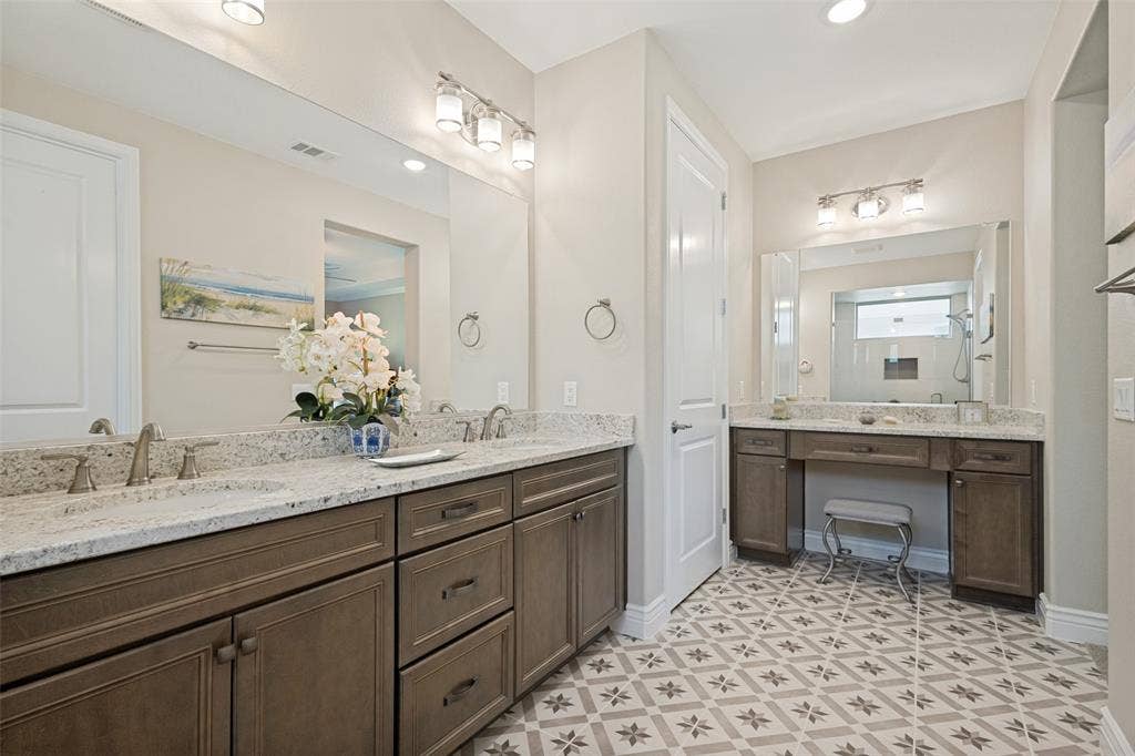 A ON TREND CERAMIC TILE FLOOR IN BEAUTIFUL NEUTRAL DESIGN IS A SHOW STOPPER. DUAL SINK VANITY WITH GRANITE COUNTERS AND A SEPERATE VANITY TOO. UPGRADED LIGHTING AND HARDWARE FINISH THE SPACE.
