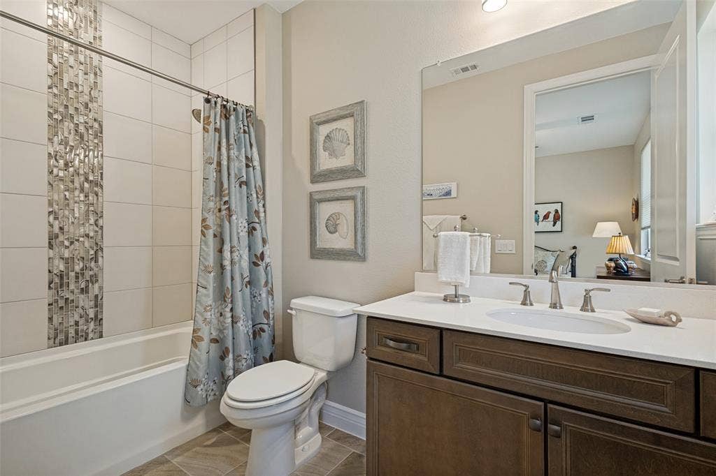 SECONDARY BATH UPGRADED WITH LARGE CERAMIC PLANK TUB SURROUND WHICH EXTENDS TO CEILING AND MOSAIC IRRIDESCENT TILES OFFER SUCH A HIGH END FINISH. QUARTZ COUNTERS AND DESIGNER LIGHTING ALSO.