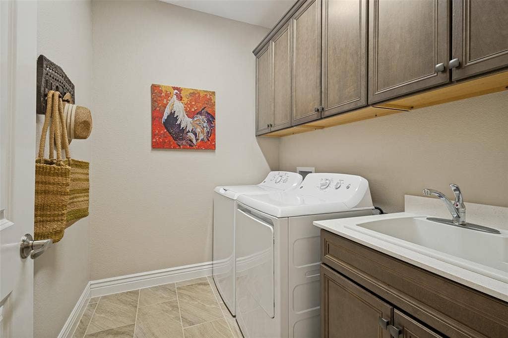 LAUNDRY ROOM IS COMPLETE WITH FULL SIZE WASHER AND DRYER, SINK AND UPPER AND LOWER CABINETS.