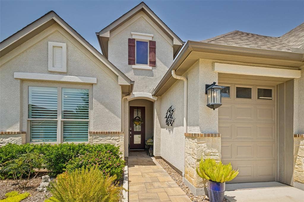 PAVESTONE WALKWAY, DIVIDED LIGHT ENTRY DOOR, DESIGNER LANTERNS, ELEVATION W GOLF CART GARAGE.