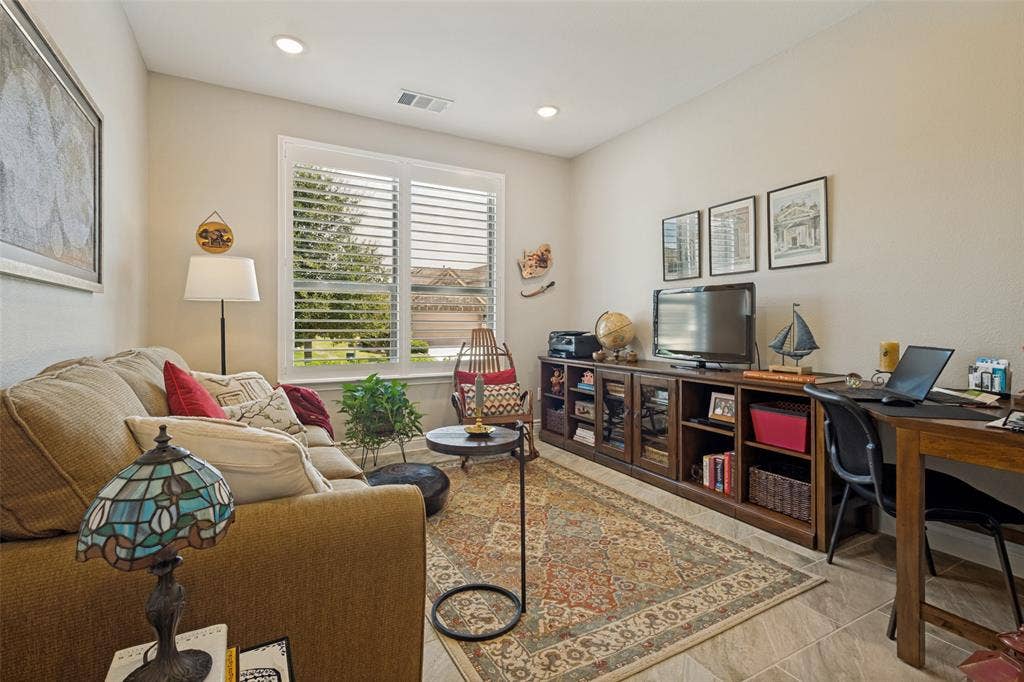 THE DEN/STUDY IS LOCATED JUST OFF THE ENTRY AND FEATURES PLANTATION SHUTTERS.