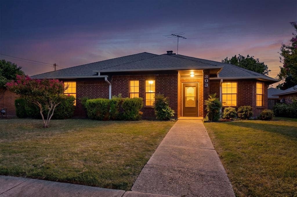 303 Stoneybrook Drive, Wylie, TX 75098 Brick exterior with dark roofline and prominent address numbers