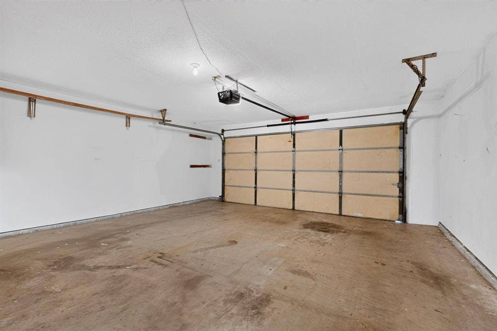 303 Stoneybrook Drive, Wylie, TX 75098 Attached garage featuring a concrete floor, automatic garage door opener, and overhead lighting