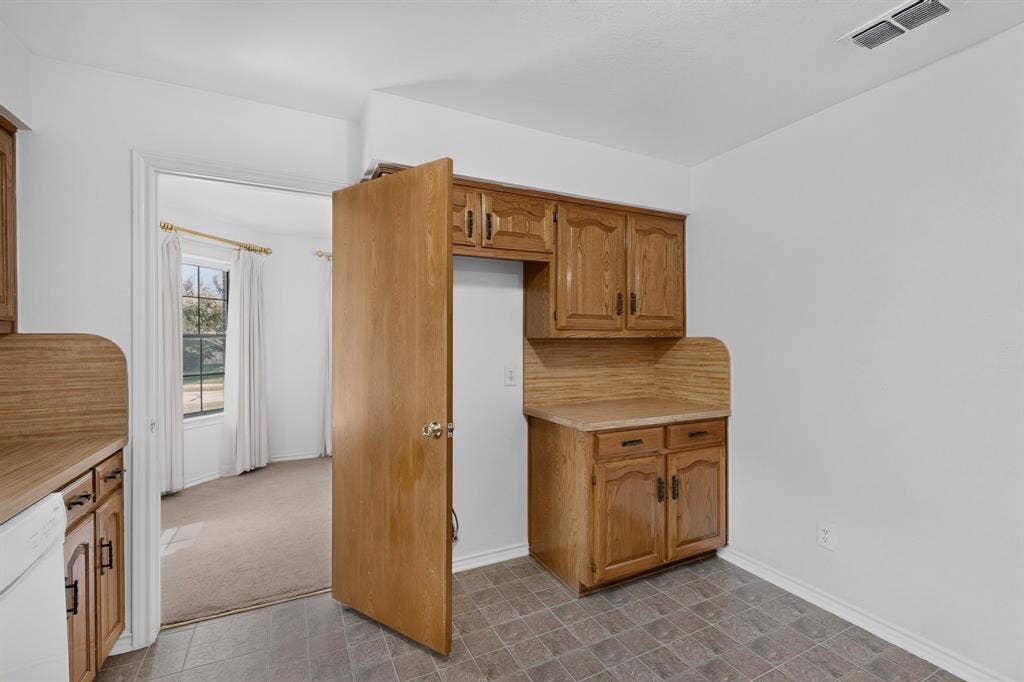 303 Stoneybrook Drive, Wylie, TX 75098 Kitchen featuring wood cabinetry, laminate countertops, and tile flooring