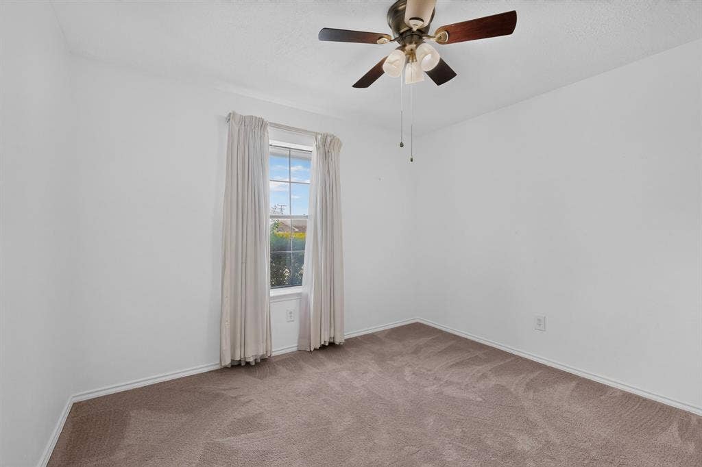 303 Stoneybrook Drive, Wylie, TX 75098 Bright bedroom showcasing neutral carpet flooring, ceiling fan with integrated lighting fixture, and a glass door opening to natural outdoor light