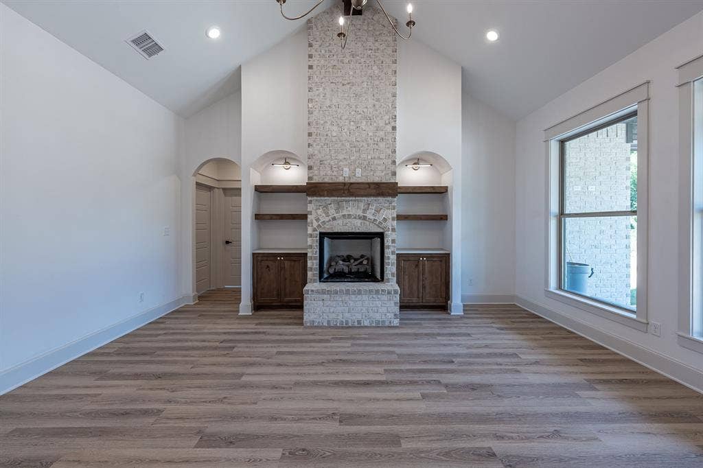 17049 Island Lake Drive, Tyler, TX 75708 Spacious great room showcasing soaring vaulted ceilings, recessed lighting, and wide-plank wood-finish flooring