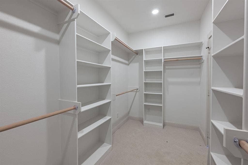 17049 Island Lake Drive, Tyler, TX 75708 Spacious walk-in closet featuring built-in shelving, multiple hanging rods, and recessed lighting