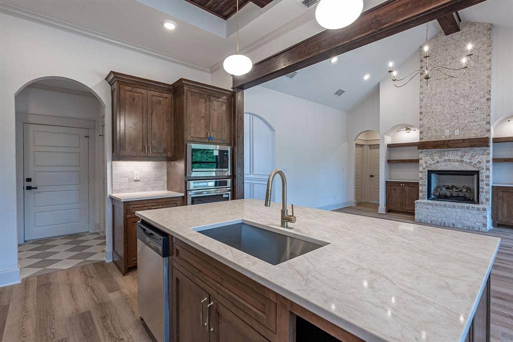 17049 Island Lake Drive, Tyler, TX 75708 Gourmet kitchen featuring a large island with an undermount sink, built-in stainless steel appliances, and wood cabinetry