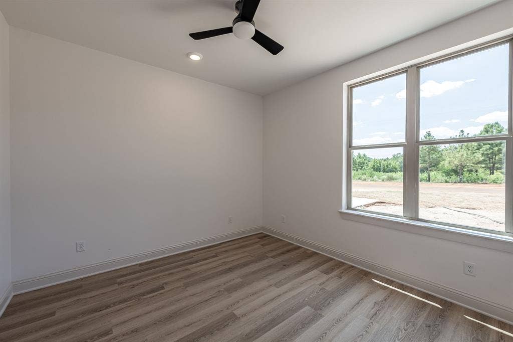 17049 Island Lake Drive, Tyler, TX 75708 Large window, wood-finish flooring, recessed lighting, and a ceiling fan