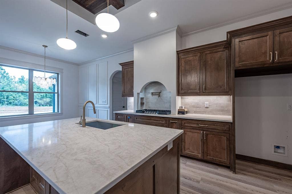 17049 Island Lake Drive, Tyler, TX 75708 Kitchen island with a large undermount sink, gooseneck faucet, and light-toned countertop