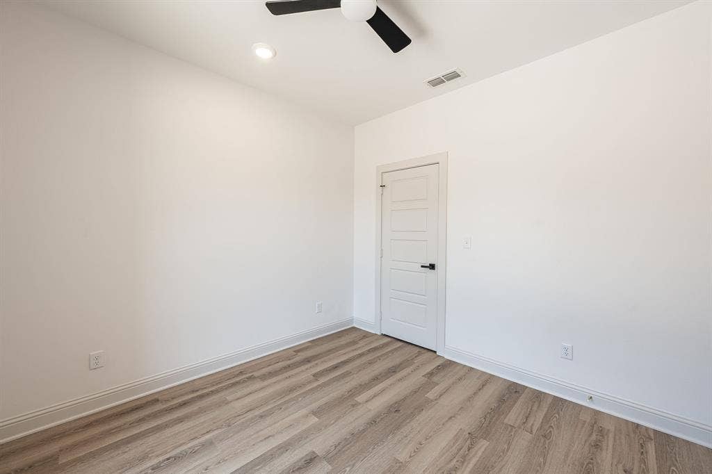 17049 Island Lake Drive, Tyler, TX 75708 Recessed ceiling light, ceiling fan with black blades, white paneled door with black hardware, and wood-finish flooring