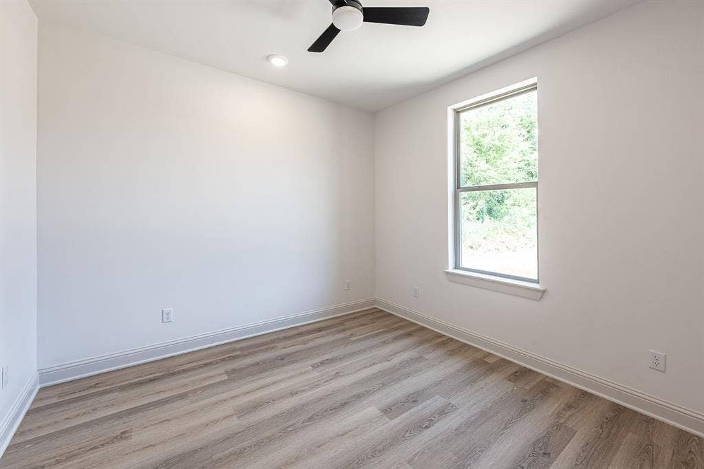 17049 Island Lake Drive, Tyler, TX 75708 Neutral wall paint, wood-finish flooring, single window, contemporary ceiling fan, recessed lighting