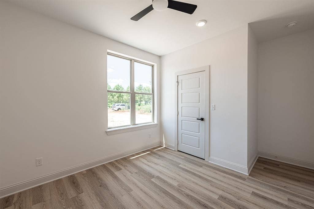 17049 Island Lake Drive, Tyler, TX 75708 Expansive window, wood-finish flooring, recessed lighting, and a contemporary ceiling fan