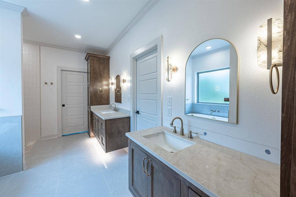 17049 Island Lake Drive, Tyler, TX 75708 Dual vanity with wood-finish cabinetry, light-toned countertops, and undermount sinks
