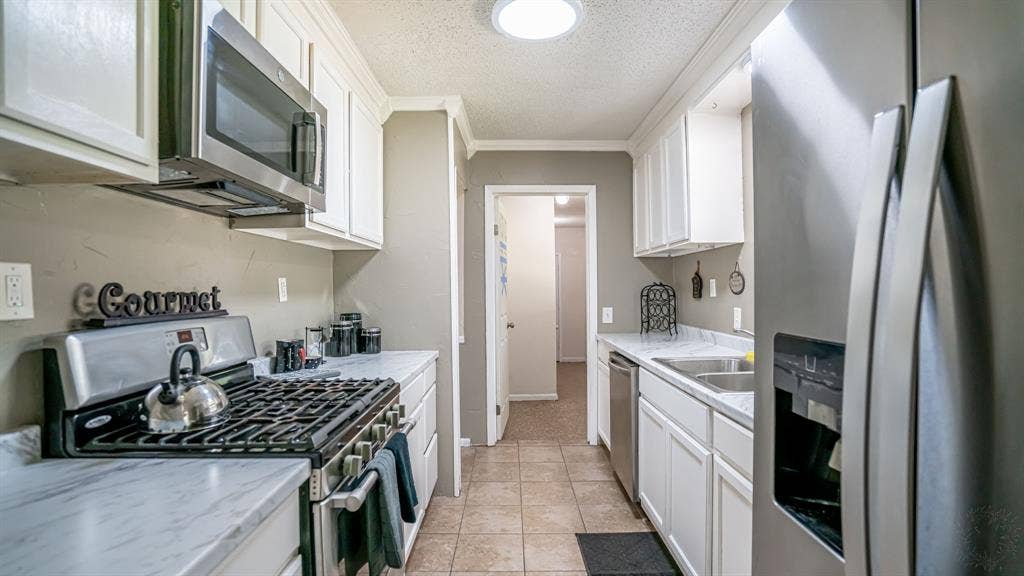 1110 Penrod Street, Granbury, TX 76048 Refrigerator, dishwasher, microwave, and gas range.