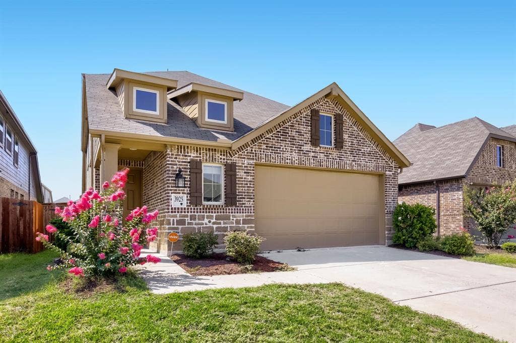 3925 Chesapeake Lane, Heartland, TX 75126 Brick and stone exterior with dormer windows, attached two-car garage, and concrete driveway