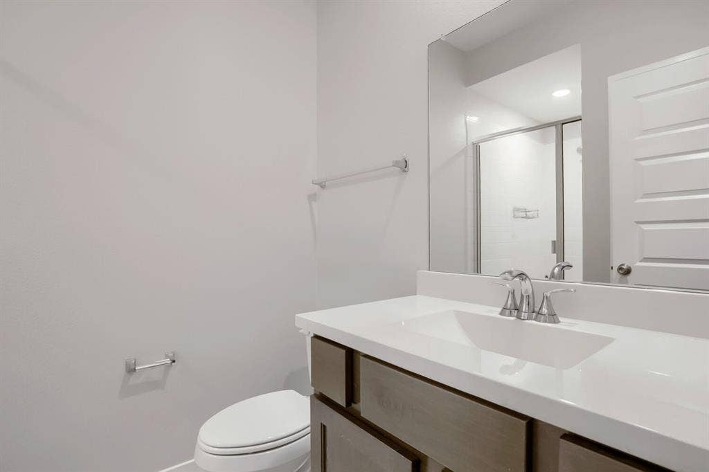 3925 Chesapeake Lane, Heartland, TX 75126 Bathroom featuring a vanity with an integrated sink, polished chrome faucet, and a large mirror