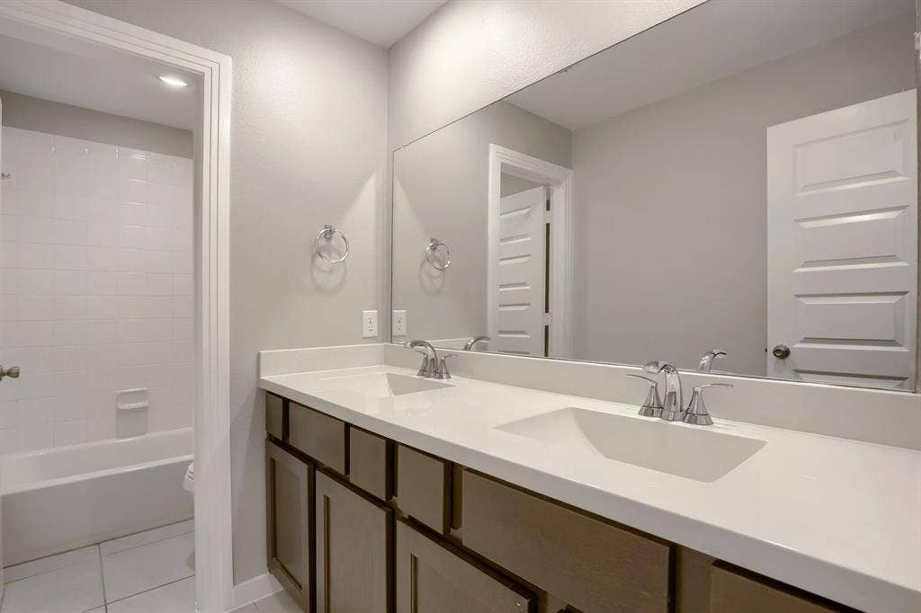 3925 Chesapeake Lane, Heartland, TX 75126 Dual vanity with integrated sinks, chrome fixtures, and a large wall-mounted mirror