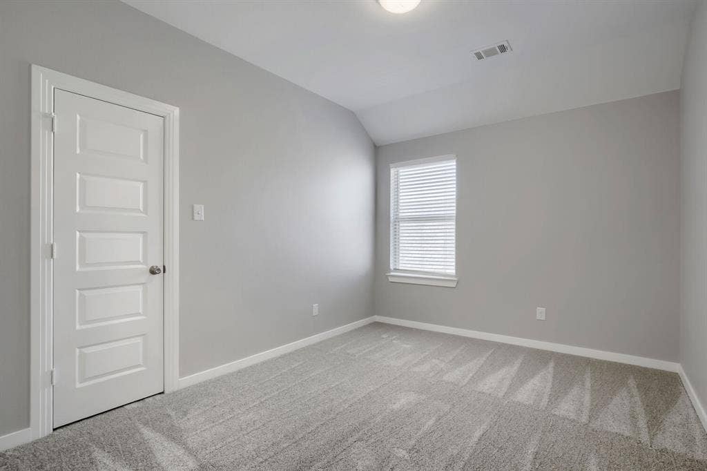 3925 Chesapeake Lane, Heartland, TX 75126 Bright secondary bedroom featuring neutral gray walls, recessed ceiling lighting, carpet flooring, and a large window with plantation shutters allowing natural light