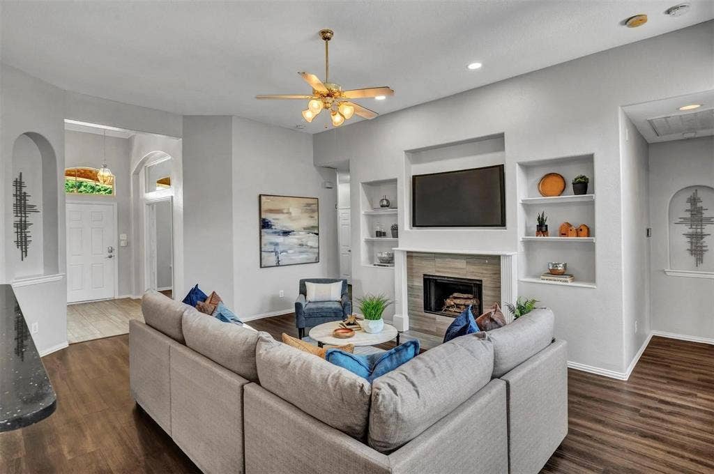 1601 Long Prairie Court, Allen, TX 75002 Open-concept living room anchored by a linear fireplace with built-in shelving and a mounted television