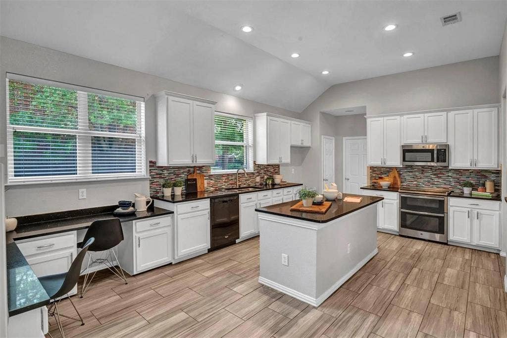1601 Long Prairie Court, Allen, TX 75002 Kitchen featuring a central island, recessed lighting, wood-finish flooring, white cabinetry, and stainless steel appliances