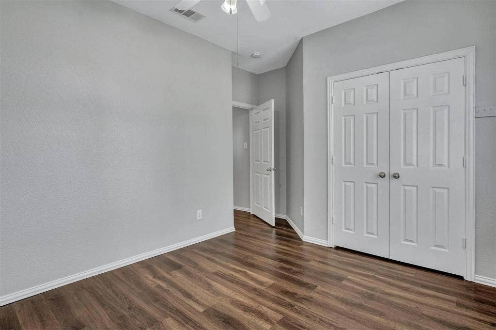 1601 Long Prairie Court, Allen, TX 75002 Spacious bedroom with warm wood-finish flooring, neutral painted walls, and abundant natural light