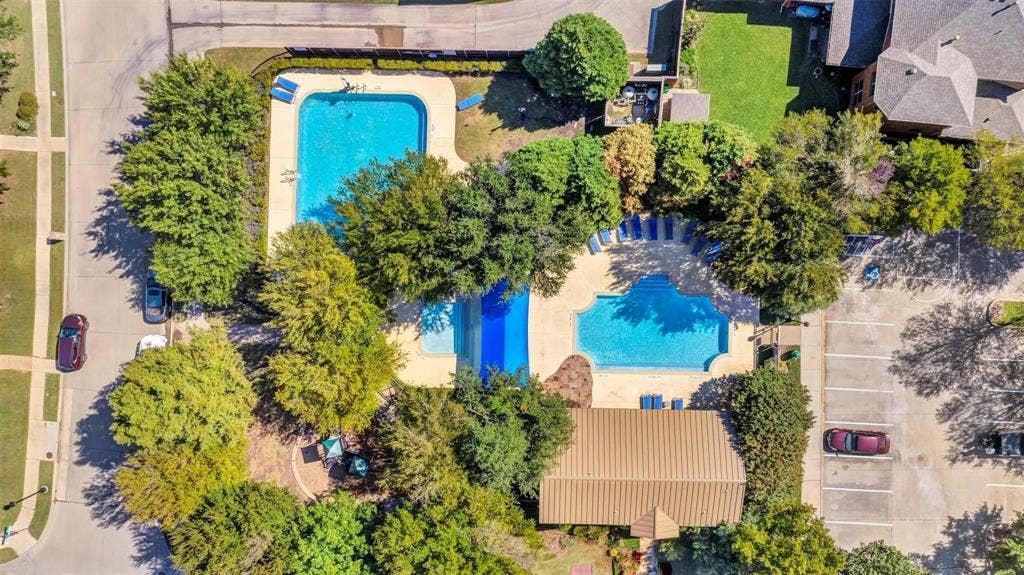 1601 Long Prairie Court, Allen, TX 75002 Community amenities include multiple swimming pools, extensive landscaping, a paved parking area, and mature trees