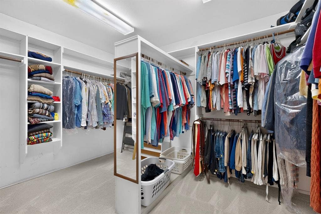 3820 Nash Lane, Plano, TX 75025 Custom-designed closet with integrated shelving, multiple hanging rods, and a full-length mirror