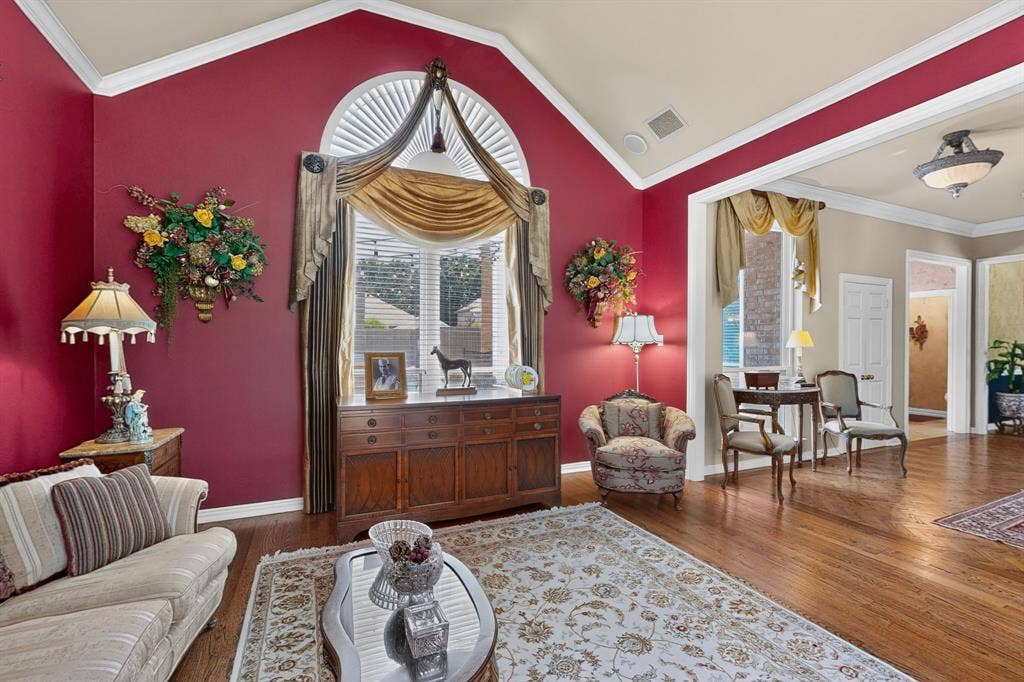 3820 Nash Lane, Plano, TX 75025 Vaulted ceiling with crown molding, arched window with plantation shutters, wood-finish flooring, built-in cabinetry, and recessed lighting