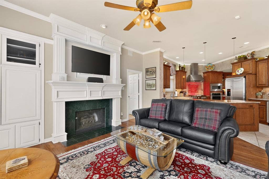 3820 Nash Lane, Plano, TX 75025 Built-in entertainment center with fireplace, custom white millwork, wood-finish flooring, and crown molding