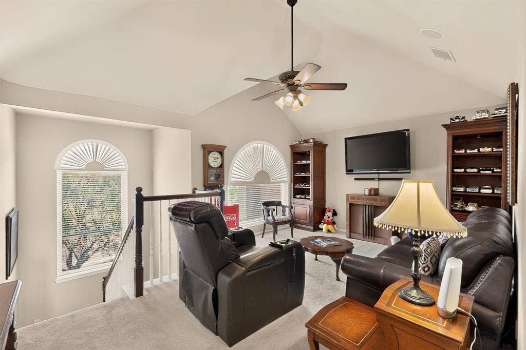 3820 Nash Lane, Plano, TX 75025 Vaulted ceiling with a ceiling fan, dual arched windows, built-in shelving, and carpeted flooring