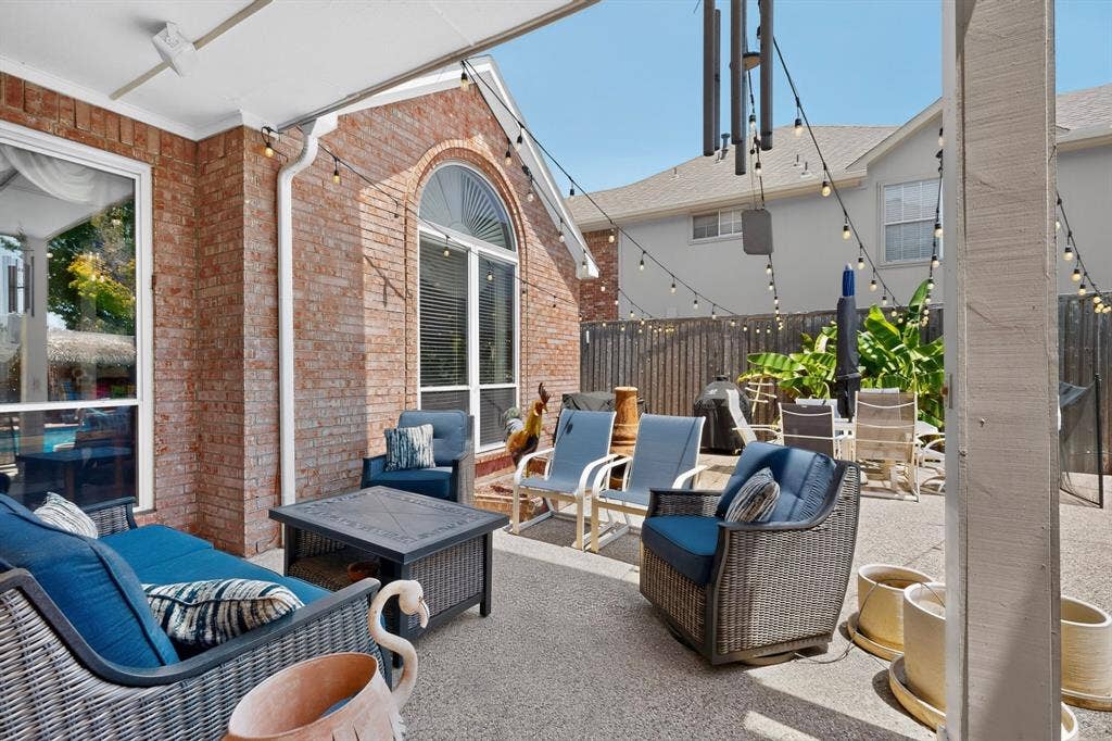 3820 Nash Lane, Plano, TX 75025 Brick exterior with a covered patio, arched window, and string lighting