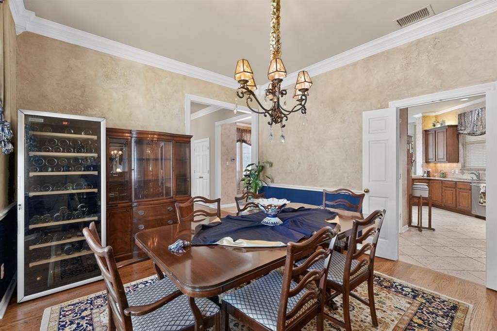3820 Nash Lane, Plano, TX 75025 Hardwood flooring, crown molding, and a decorative chandelier illuminate this space
