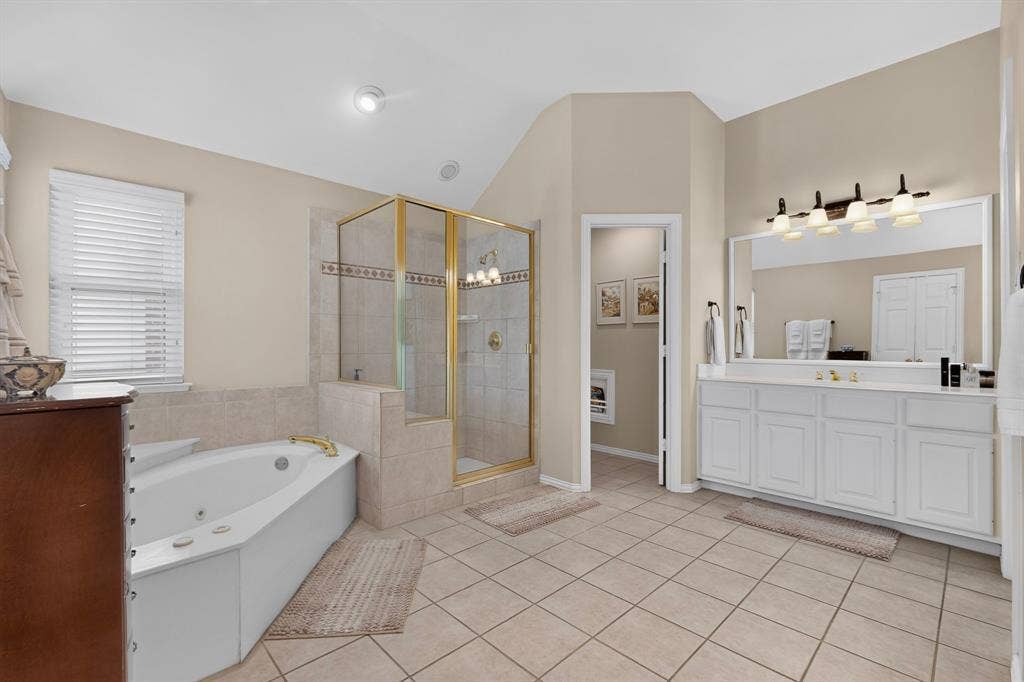 3820 Nash Lane, Plano, TX 75025 Expansive bath featuring a large soaking tub, separate glass-enclosed shower, dual vanity with extensive counter space, and tiled flooring